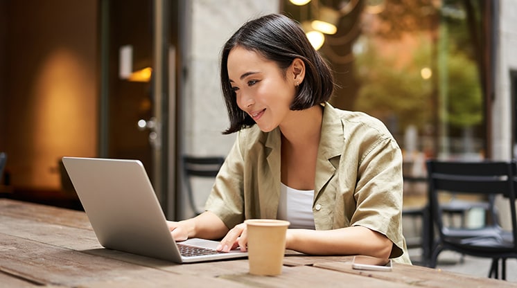 Woman wearing a tan button up shirt on computer