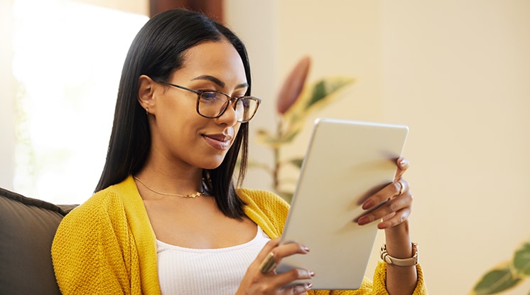 Person in yellow sweater and glasses checking health coverage options