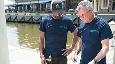 Two workers by a pier