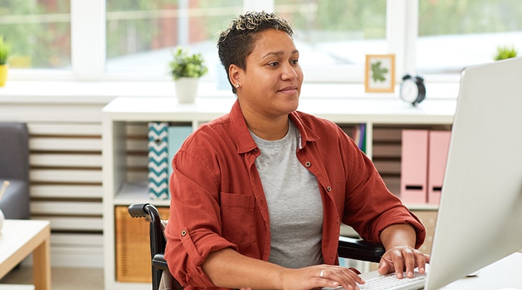 Person in red shirt on computer looking right